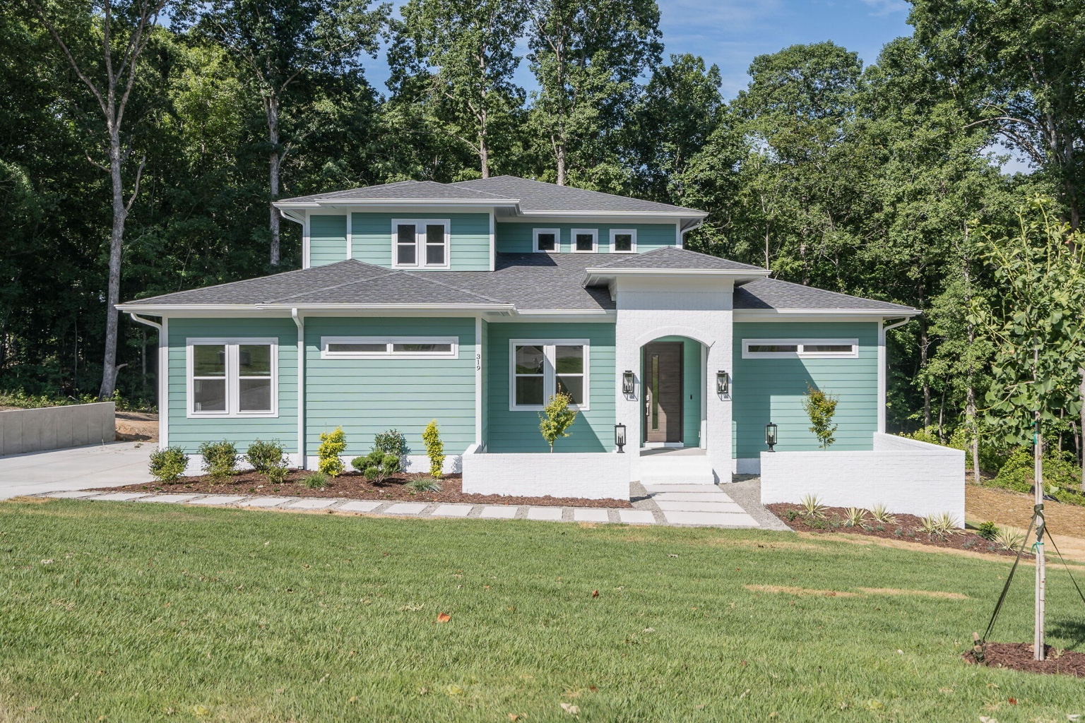 Green siding and white brick Kirkwood custom home front elevation